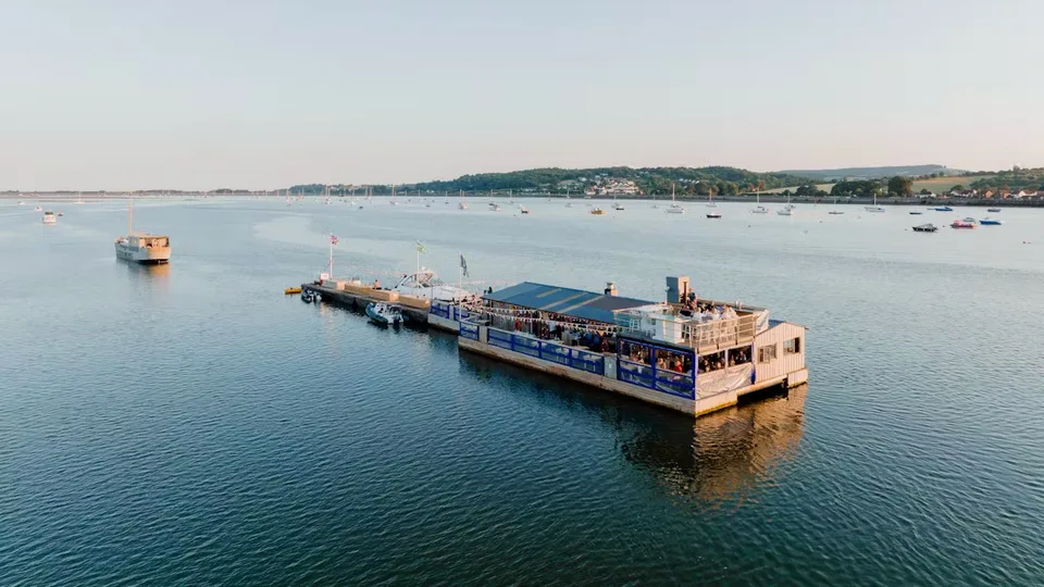 The River Exe Café, a floating barge moored on the Exe Estuary at dusk